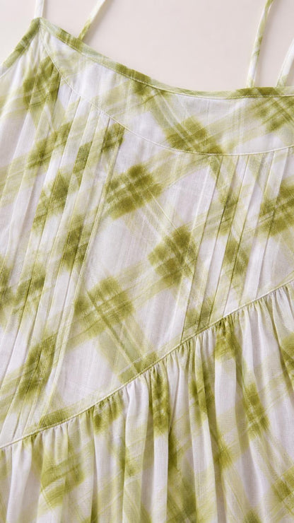 Close-up of fabric texture and pattern on green plaid dress