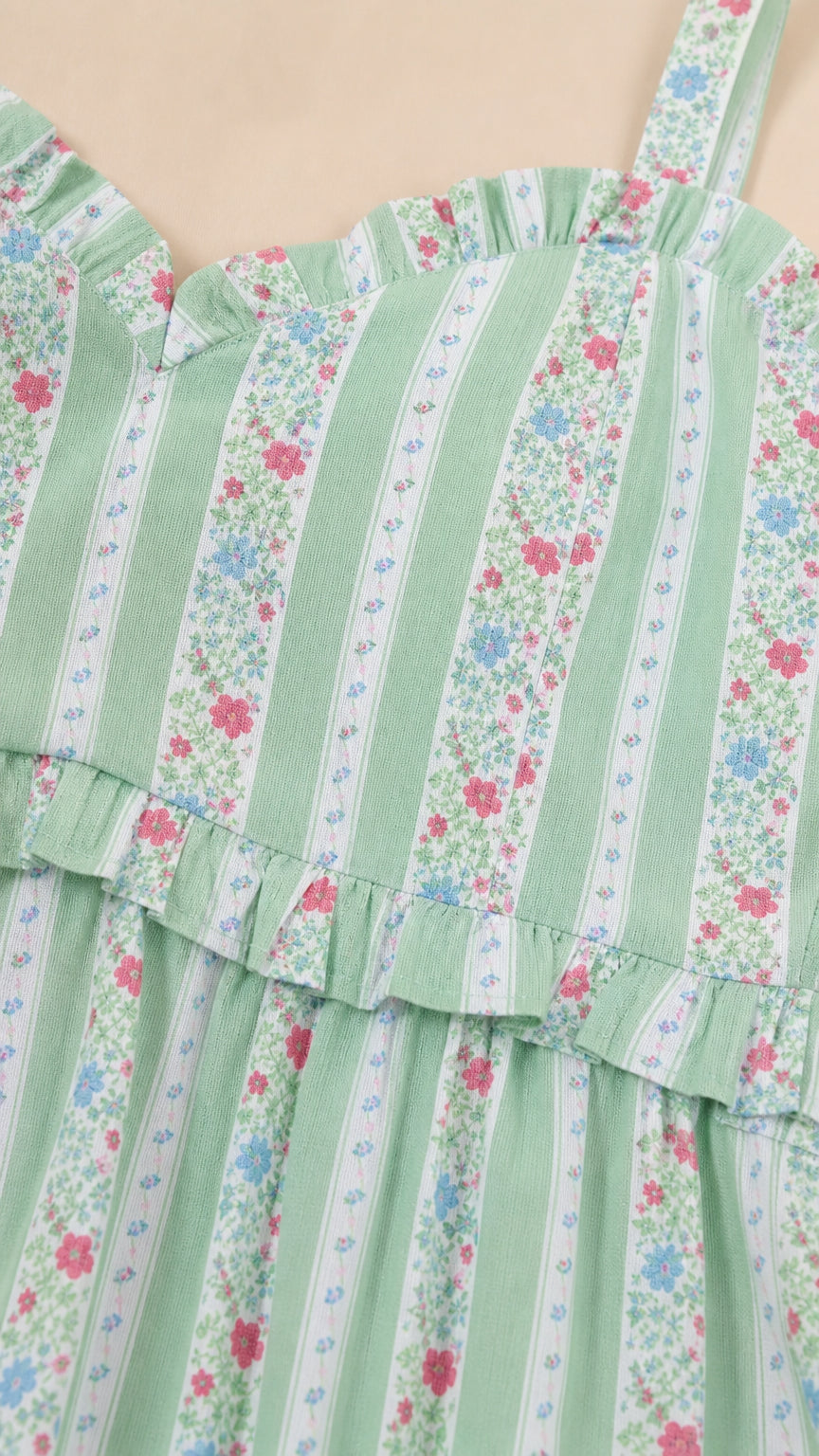 Close-up detail of neckline, ruffles, and pattern on green dress