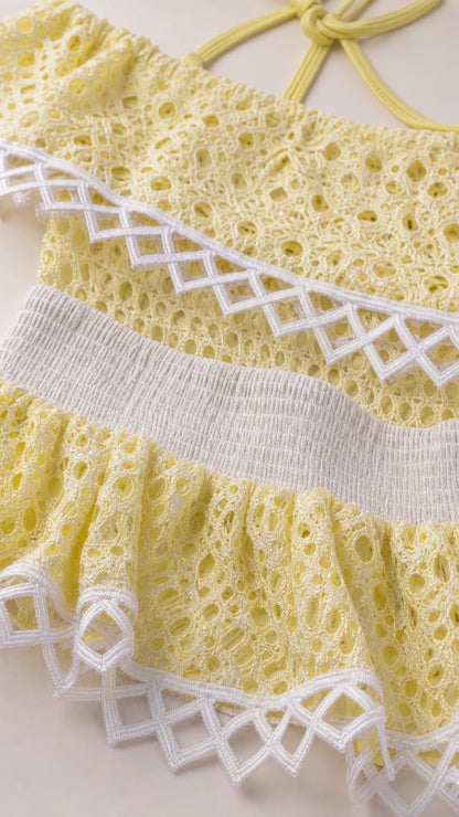 Close-up detail of yellow eyelet lace and geometric trim