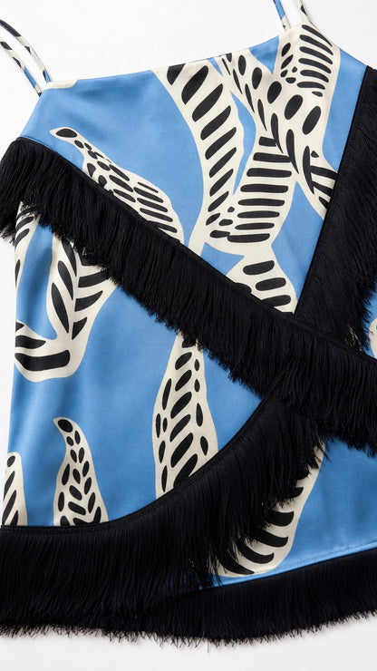 Close-up detail of blue printed fabric and black fringe trim