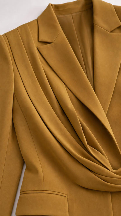 Close-up detail of mustard blazer lapel and asymmetric draped wrap