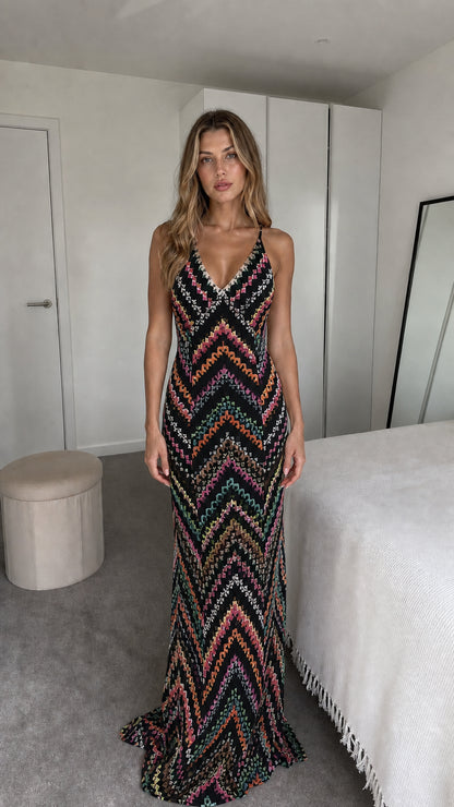 Front view of model wearing black chevron maxi dress