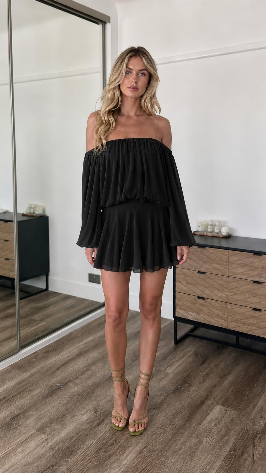 Front view of model wearing black off-the-shoulder mini dress