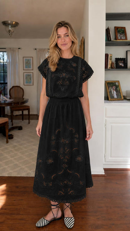 Woman wearing black embroidered short sleeve midi dress