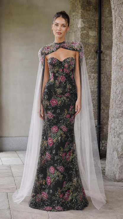 Front view of black floral embroidered corset gown with sheer cape