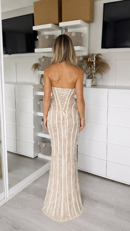 Woman wearing champagne strapless lace corset maxi dress back view