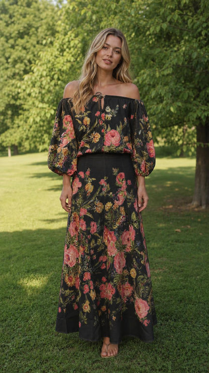 Front view of model wearing black floral off-the-shoulder maxi set