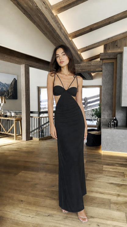 Model wearing black cutout halter maxi dress