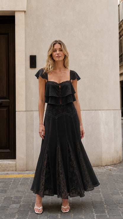 Front view of woman wearing black ruffled two-piece maxi set