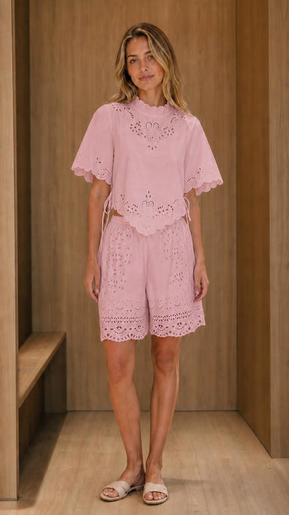 Model wearing pink eyelet embroidered top and shorts set