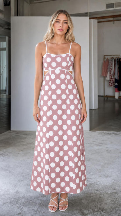 Front view of woman wearing pink polka dot maxi dress