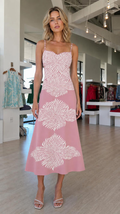 Model wearing pink knit midi dress with white abstract floral motifs