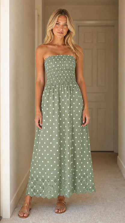 Front view of woman wearing green polka dot strapless maxi dress
