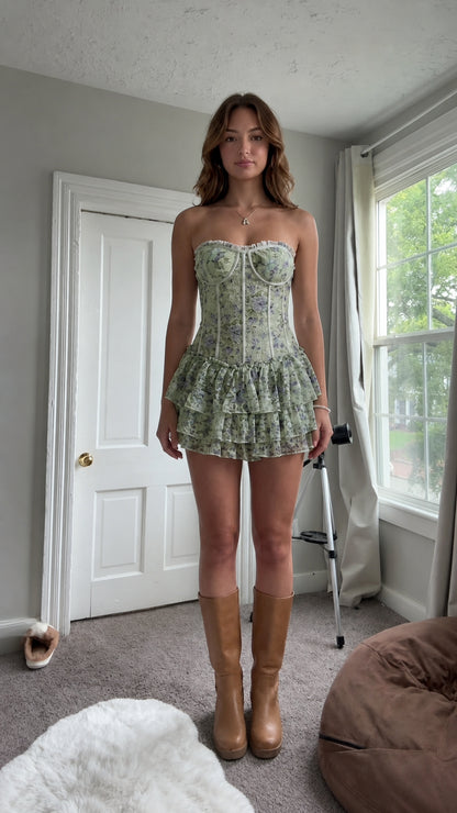 Front view of woman wearing sage green floral strapless corset mini dress