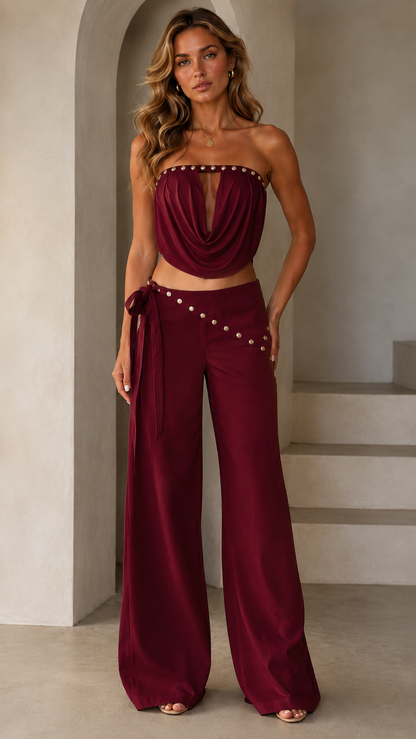 Model wearing burgundy strapless top and wide leg pants set