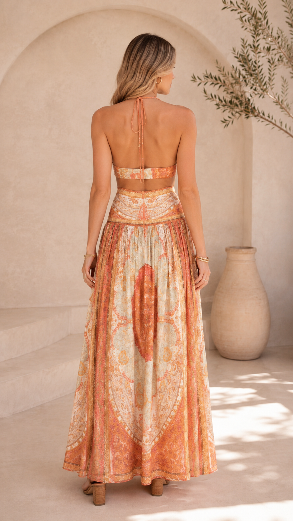 Back view of peach ornate print halter maxi dress with open back