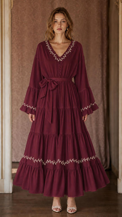 Burgundy women's tiered maxi dress with V-neckline, contrast botanical trim, and side bow