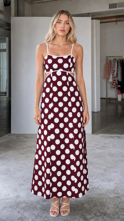 Front view of woman wearing burgundy polka dot maxi dress