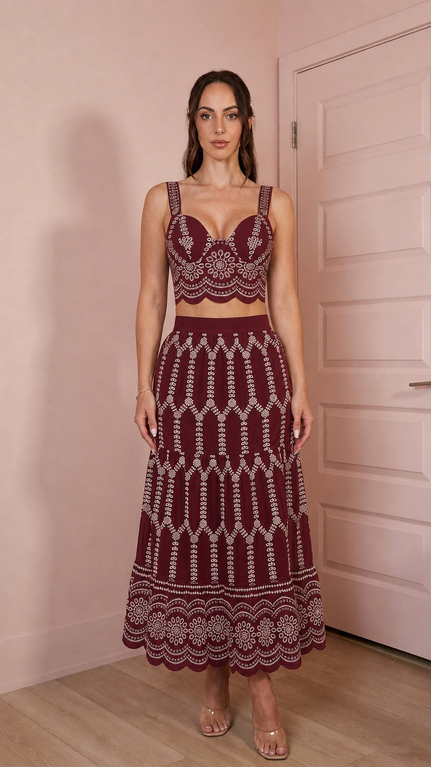 Model wearing burgundy two-piece embroidered crop top and skirt set