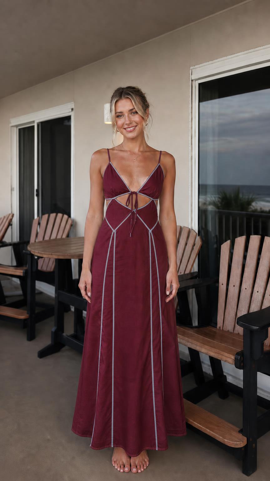 Front view of woman wearing burgundy maxi dress with white contrast piping