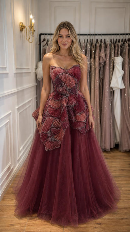 Woman wearing burgundy strapless beaded tulle ball gown