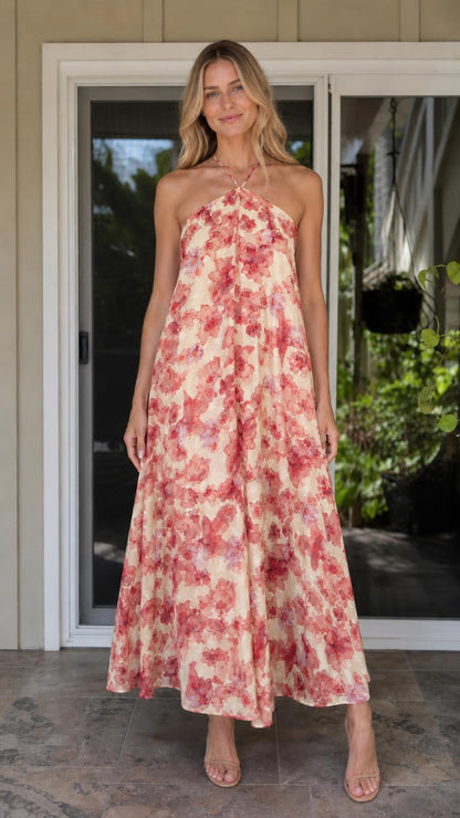 Model wearing cream and pink floral print halter maxi dress