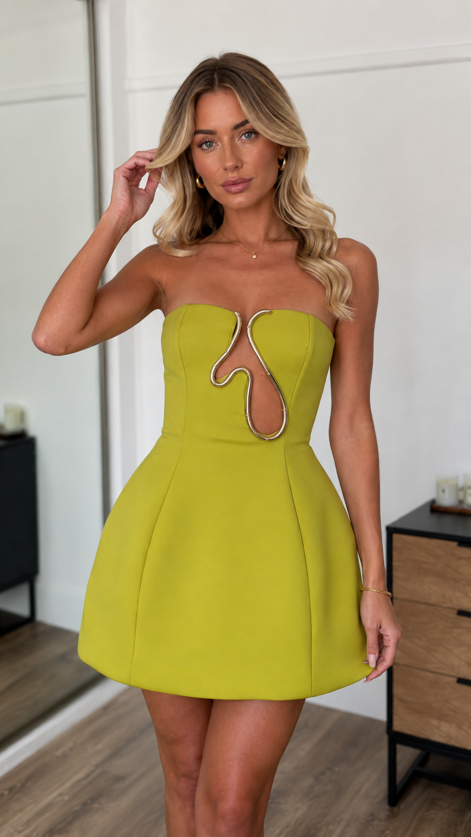 Model wearing chartreuse green strapless mini dress with metal cutout accent, front view